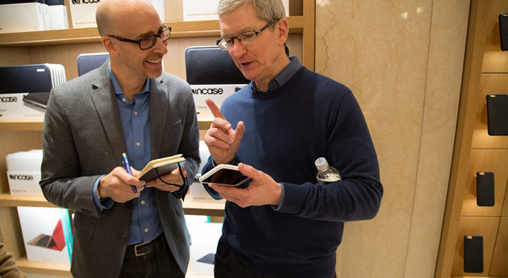 Apple CEO Tim Cook (right) explains the hump on Apple's new iPhone Smart Battery Case. (Mashable.com)